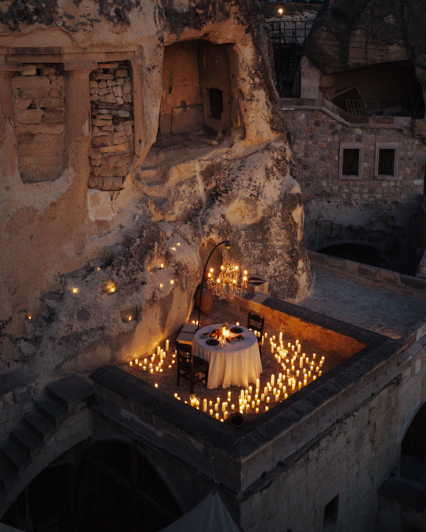 Candlelit terrace with a view of Uçhisar Castle at dusk